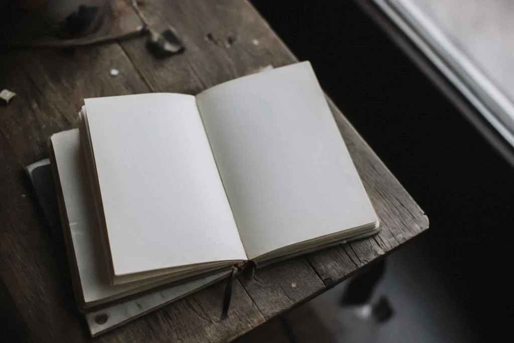 A blank old notebook on a table, left open as if remembering something.